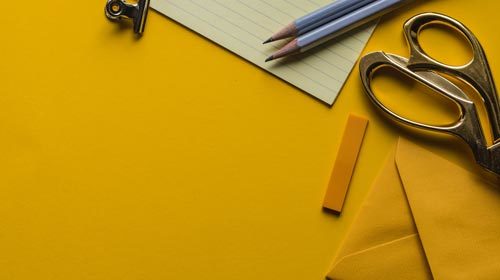 scissors, pencil, and paper on a desk