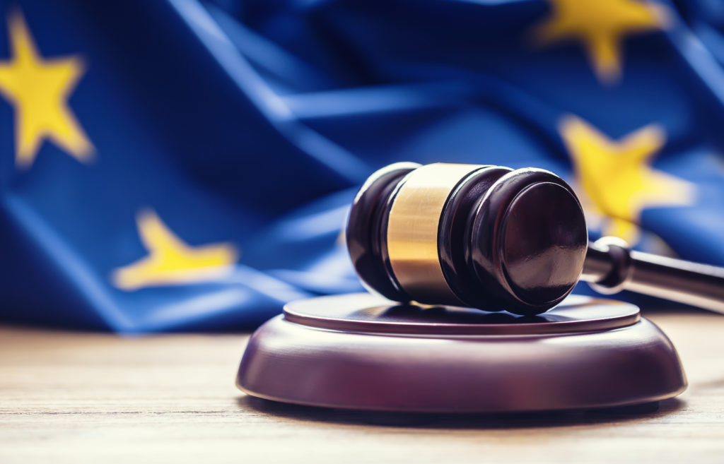 wooden gavel with EU flag in the background
